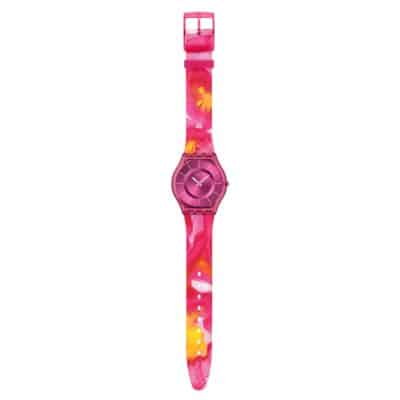 Montre Swatch Skin Paradise Mist cadran rose avec un effet brossé soleil, boîtier biosourcé mat transparent rose et bracelet mat transparent rose à motif multicolore.