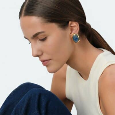 Boucles d'oreilles boutons à clip de notre collection RIVIERA, imaginées à Paris, réalisées en laiton doré 750/1000e - 18 carats et ornées de kyanite. Cette collection iconique met en valeur les pierres naturelles. Boucles d’oreilles pour oreilles non percées avec système clip.