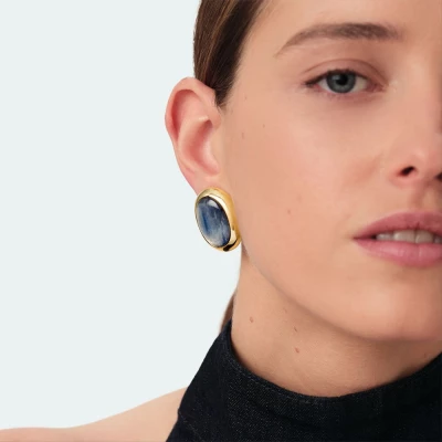 Boucles d'oreilles boutons collection RIVIERA, imaginées à Paris, réalisées en laiton doré 750/1000e - 18 carats et ornées de kyanite. Cette collection iconique met en valeur les pierres naturelles.